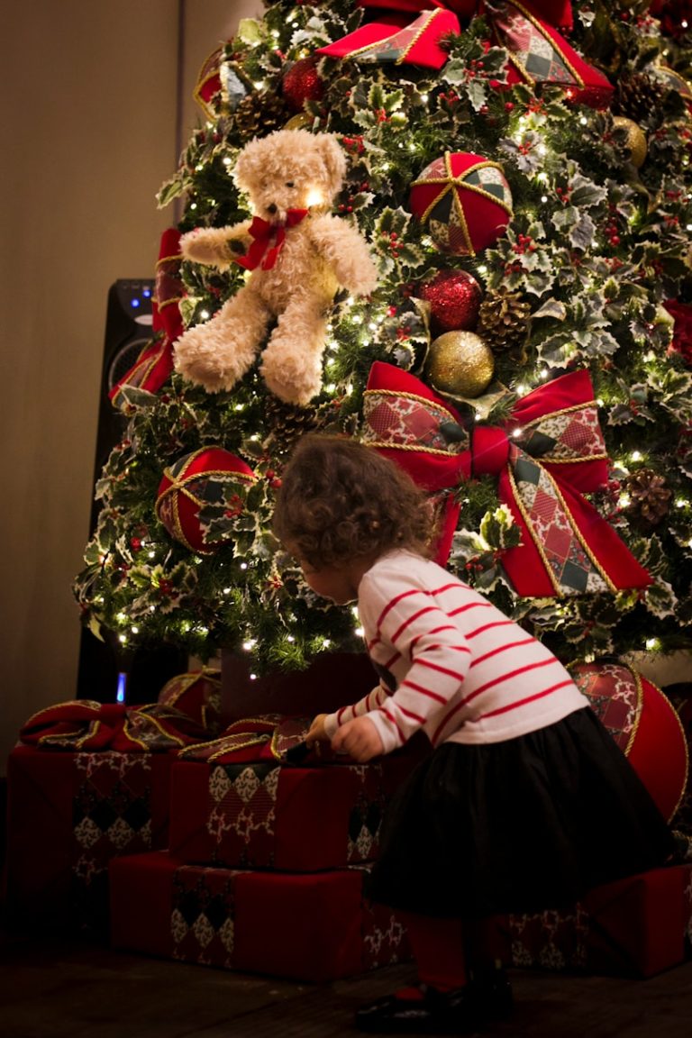 girl picking gift in front of pre-lit tree